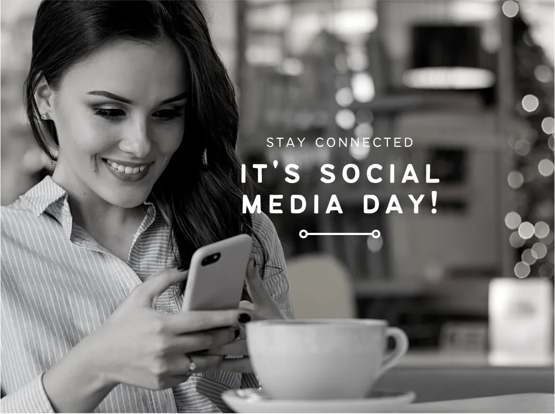 Woman smiling at her phone in a café
